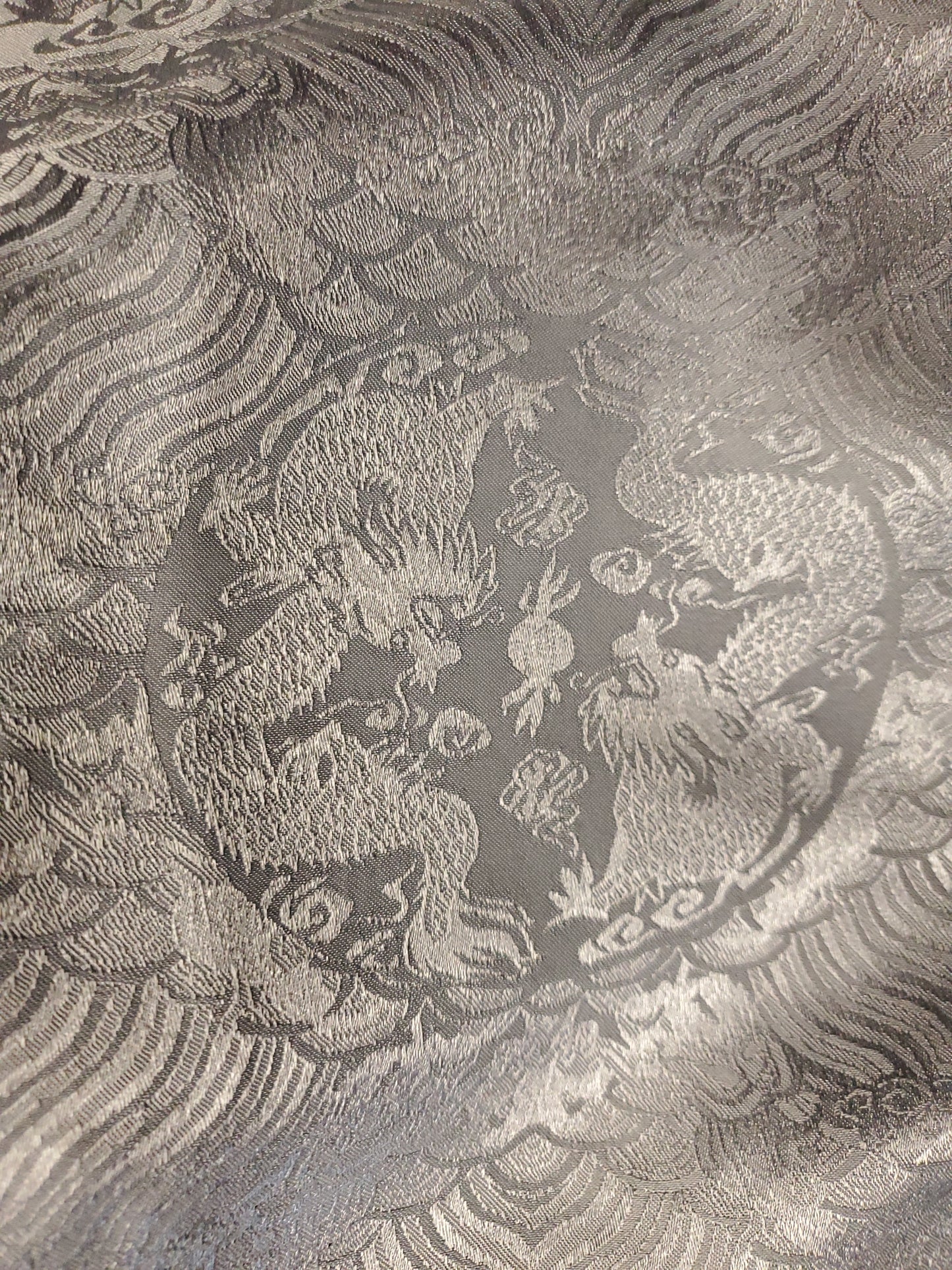 Decorative fabric with intricate dragon pattern on a textured background