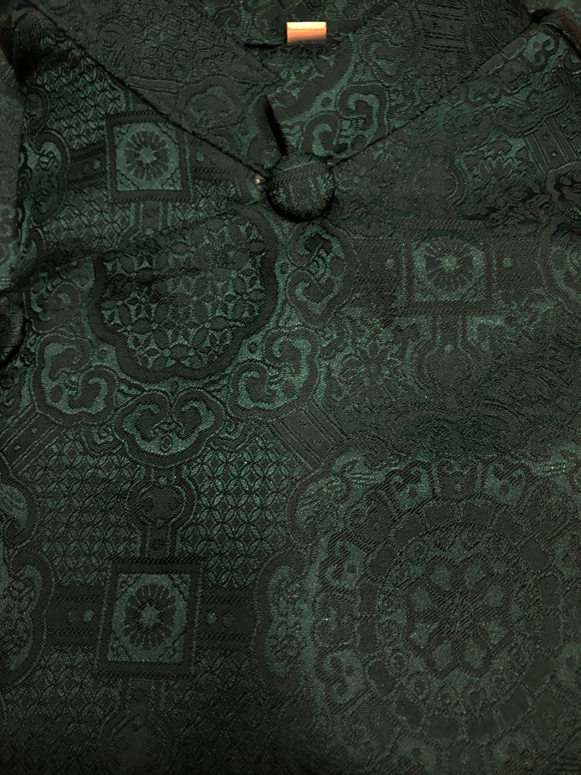 Dark green patterned fabric with a close-up view
