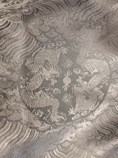 Decorative fabric with intricate dragon pattern on a textured background